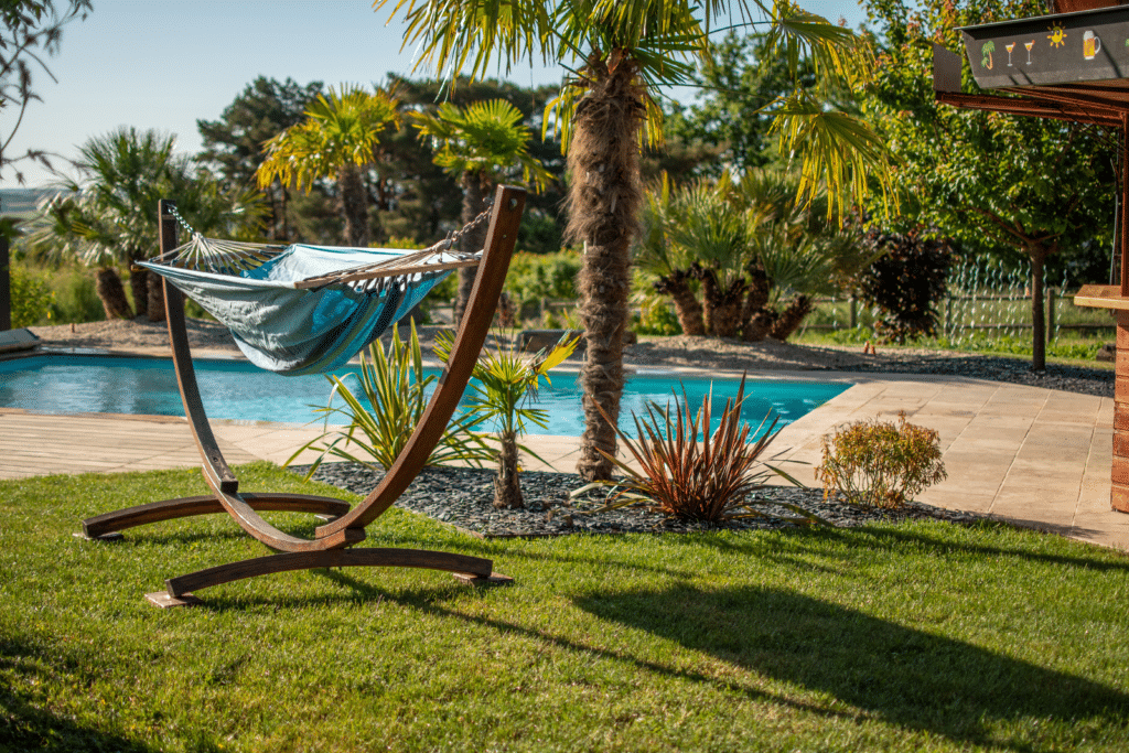 Transat dans un jardin soigné avec palmiers et piscine