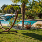 Transat dans un jardin soigné avec palmiers et piscine