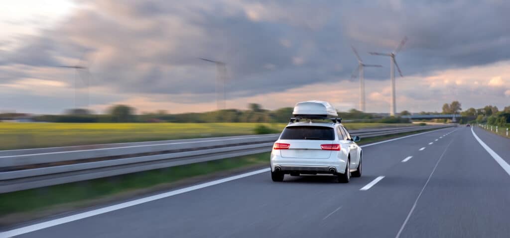 voiture blanche roulant sur l'autoroute avec un coffre de toit