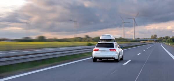 voiture blanche roulant sur l'autoroute avec un coffre de toit