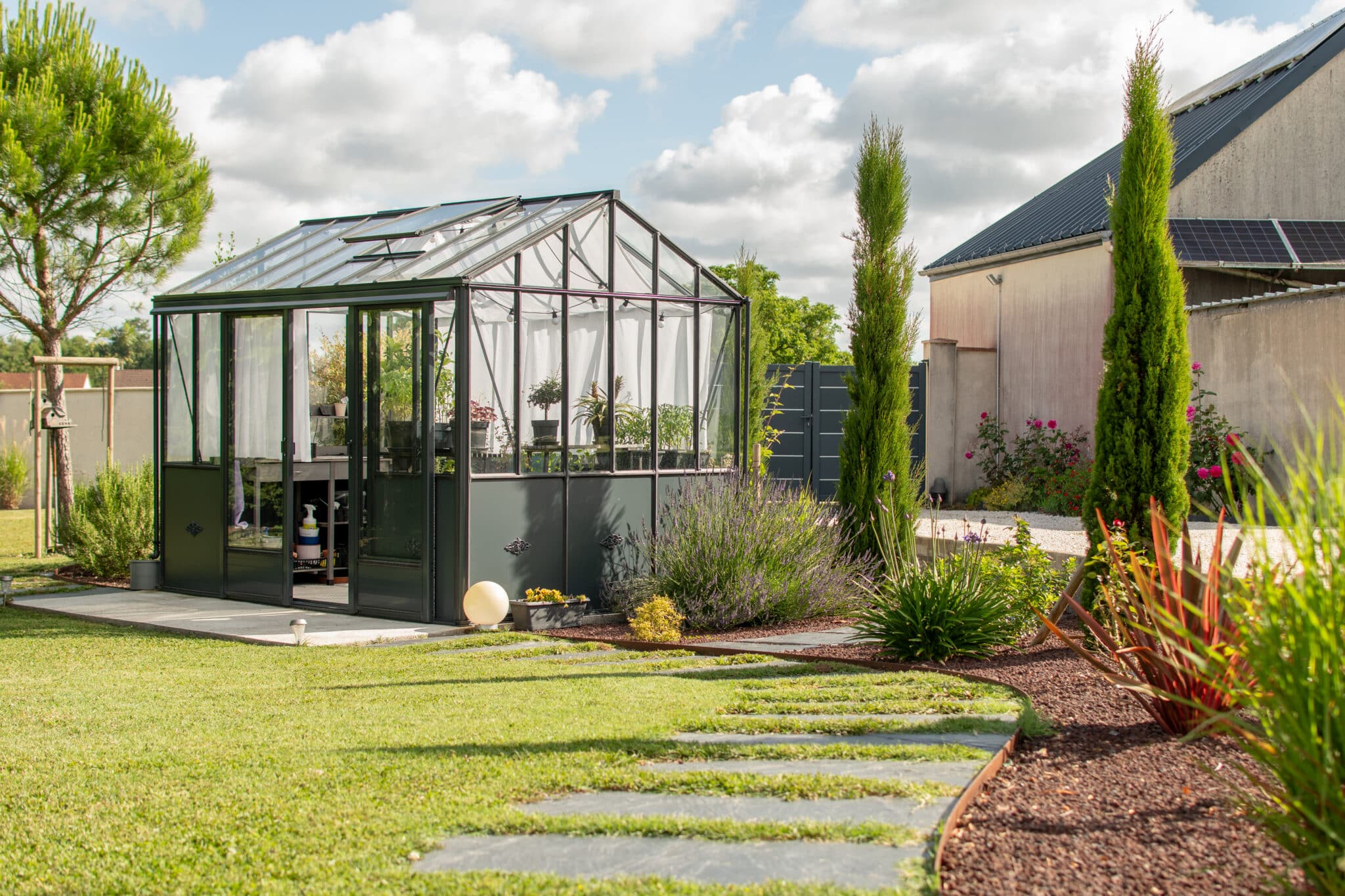 serre Jardin entretenus avec des plantes et une serre