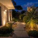 entrée de maison avec des dalles de nuit éclairées par des petites lampes