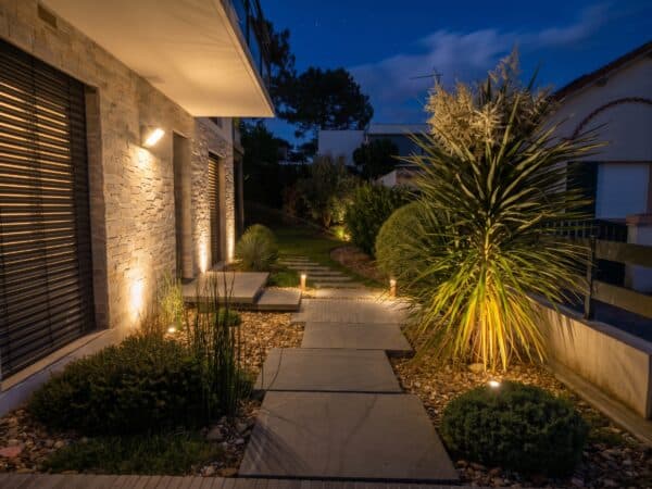 entrée de maison avec des dalles de nuit éclairées par des petites lampes